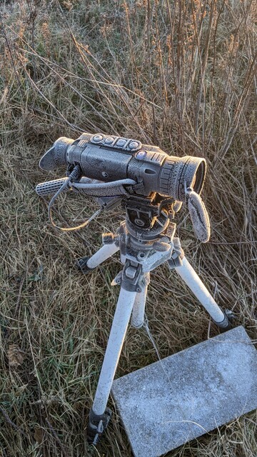 Camera on a tripod weighted down by a cement brick to keep it stable in the wind. The camera is covered with a substantial layer of frost. The question remains: will it turn back on?