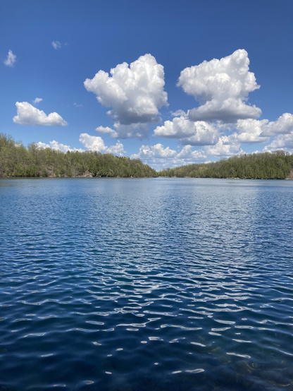 A beautiful sunny day with white fluffy clouds over a beautiful lake