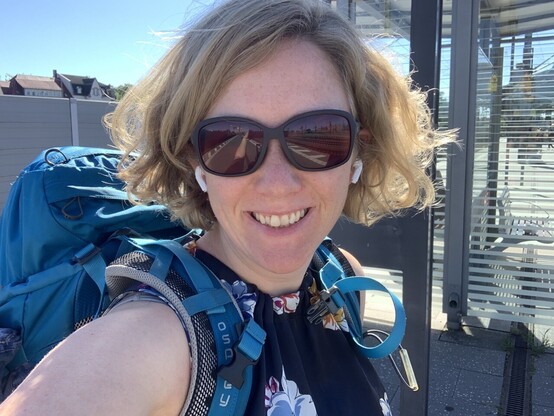 Selfie of myself with my big blue backpack at the station. Here we go!! 🥳