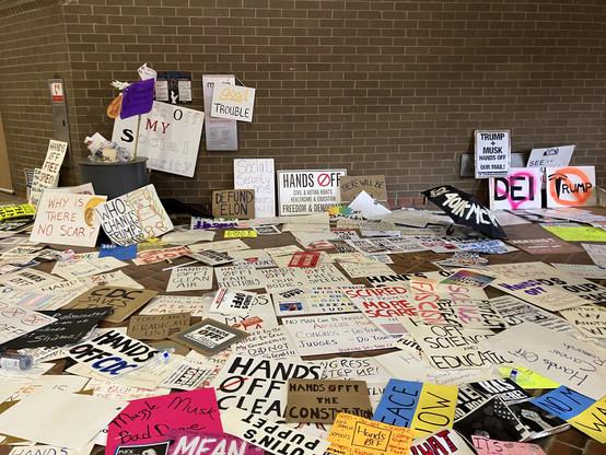 Scene at the MARTA station at the end of the day, where many people left their protest signs strewn on the wall and floor. Most of them are in the "Hands Off" theme of today's protest: "Hands off the CDC" is a prominent one.