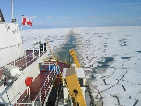 image/jpeg an icebreaker ship flying a Canadian flag creates a path of broken ice, which is slightly green-brown tinged. CCGS Griffon, photo from S. Wilhelm.